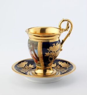  An elegant navy blue and gold cup and saucer set with intricate decorative patterns, displayed against a white background.