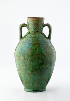  A tall, slender ancient-style ceramic vase with a mottled green patina and two small handles near the neck, featuring a subtle texture reminiscent of foliage on its surface.