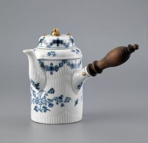  A porcelain teapot with a white and blue floral pattern, a fluted body, a dark brown wooden handle, and gilded accents on the lid, set against a light gray background.