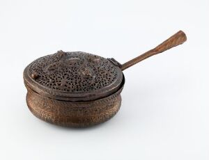  An antique-looking, intricately patterned metallic container with a filigreed lid and a wooden handle, possibly an incense burner or spice box, set against a white background.