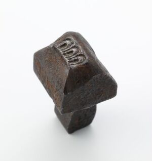  An aged hexagonal metal nut with the measurements "9/16" stamped on the top, set against a plain white background.