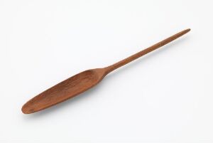  A simple wooden spoon with a warm hue and visible grain patterns lying on a light off-white background.