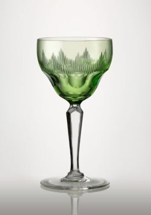  An exquisite blown glass wine glass with facet, olive, and star cut decorations by Ragnvald Hansen, featuring a detailed forest silhouette in lighter green encircling the deep green colored base of the bowl, a long clear stem, and a sturdy base. The glass demonstrates fine craftsmanship and a blend of colors that create a refreshing naturalistic feel.