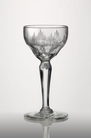  A transparent, exquisitely cut glass goblet with decorative detailing, designed by Ragnvald Hansen, against a gradient background from white to light grey.