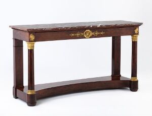  An antique mahogany console table with gold accents and a possible marble inset top against a plain, neutral background.