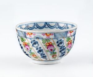  A porcelain bowl with a flared rim featuring a vibrant, multicolored floral design on a white background. The bowl has decorative blue arcs around the rim and is placed against a gradient white to grey backdrop.