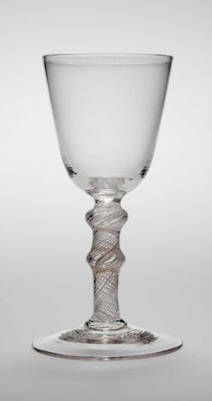  A clear glass goblet with an intricately twisted stem stands against a light grey background, highlighting its classic design and transparency.