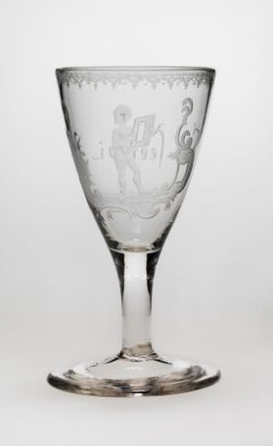  An elegant transparent glass goblet with a detailed classical scene etched into the bowl, featuring the slender stem and stable foot, set against a light gray background. Artist name and title of the work are unknown.