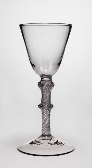  A clear glass with a conical bowl, a spiral-designed stem, and a circular base, standing against a white background.