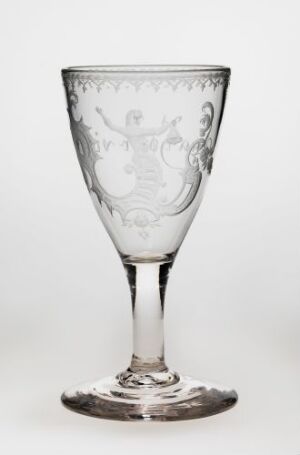  A clear etched glass with a decorative design on the bowl, a slender stem, and a solid base, set against a light, solid background.