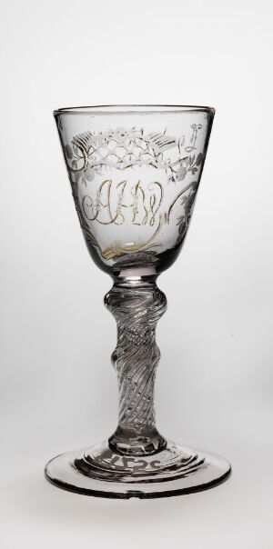  A transparent glass goblet with intricate etched designs on the bowl and a twisted stem design, set against a light grey background.