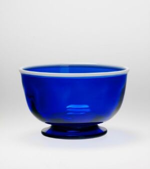  A cobalt blue bowl with a rounded shape and a flat base against a white background. Artist name and title are unknown.