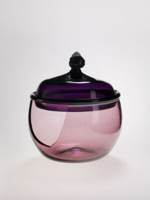  An elegant two-toned glass jar with a gradient from deep purple at the top to light pink at the bottom, featuring a purple lid with an ornamental finial, set against a plain background. Artist name and title are unknown.