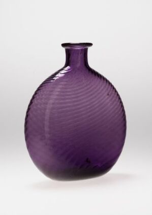  A spherical purple glass vase with vertical ribbed texture and a narrow opening at the top, set against a neutral background. The vase has subtle gradations of purple, with a play of light and shadow highlighting its texture and form.