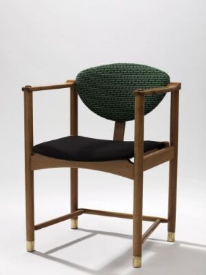  "D-stol" by Bjørn Engø, a modern chair with an oak frame featuring brass details, a black flat seat cushion, and a textured hunter green rounded backrest cushion upholstered in wool.