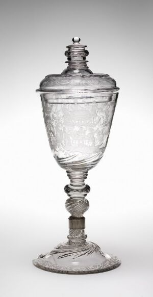  An engraved glass goblet by Heinrich Gottlieb Köhler, featuring a lidded, dome-shaped top with ornate finial, a bulbous engraved bowl, a stem with spherical beading, and a stable flat foot, all exhibiting the clear, transparent beauty of fine glassware.