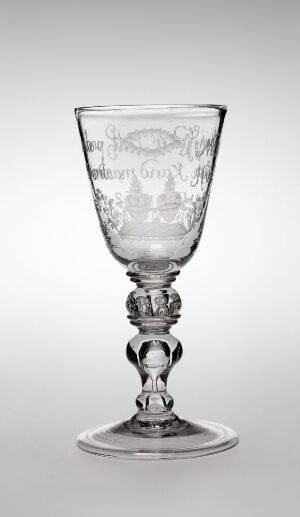  "Siegfrids Pokal 1/4 Pot," an engraved clear glass goblet by Vilas Hansen Vinter, depicting intricate designs on its bowl, with a detailed stem and base, set against a gray background.