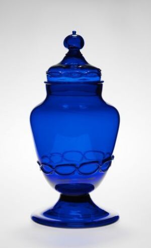  A slender cobalt blue glass jar with a decorative band of oval indentations and a matching lid, set against a white background.