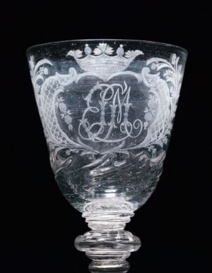  An intricately etched transparent glass goblet with a monogram "JM" in a decorative cartouche, topped with a nobility coronet, against a black background.