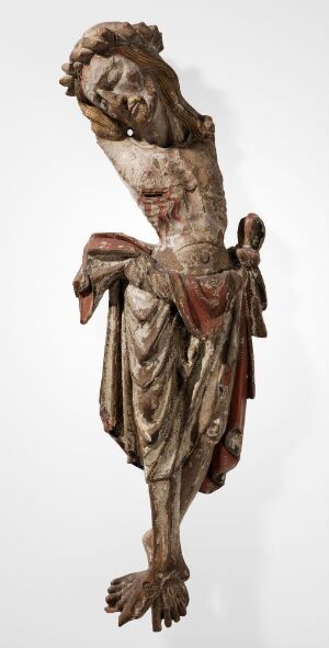  Part of an aged oak wood sculpture of Jesus Christ from a crucifix, titled "Del av krusifiks" by an unknown artist, featuring muted earthy tones with remnants of white, red, and gilded coloring on a white background. The figure has its head tilted right and eyes closed, with detailed carving to suggest fabric and anatomy.