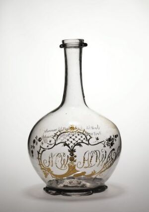  A round-bodied glass bottle with a slender neck, displaying a greenish tinge and decorated with golden motifs and script, set against a white background.