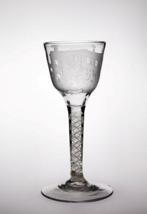  A clear glass goblet with an etched design in the bowl and a diamond-cut pattern on the stem, set against a white background.