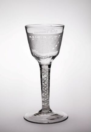  A clear glass goblet with an etched pattern around the rim and decorative circular indents on the stem, set against a light gray background.