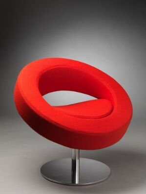  A modern designer chair by Softline A/S with a red felt upholstered, form-pressed polyurethane body on a chrome-finished steel base. The chair has a unique circular shape with a central cutout, combining both aesthetic appeal and functionality.