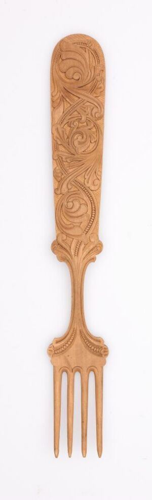  A decorative wooden fork with intricate floral carvings along its elongated handle, displayed against a white background. Artistname and title are unknown.