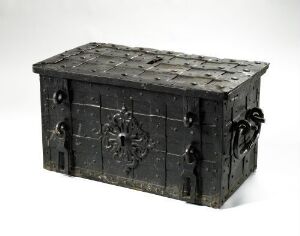 
 An antique, dark wooden chest with metal reinforcements and elaborate hardware, including side handles and a front lock, displayed against a neutral background. Artist and title are unknown.