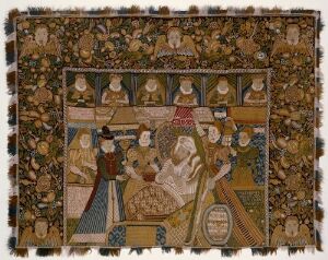  A historical textile artwork, possibly a tapestry, with a central motif showing figures in medieval attire seated at a banquet, framed by a heavily detailed border filled with smaller figures and animals in earthy tones of beige, tan, brown with highlights in blue and red.