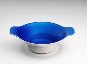  A two-tone bowl with a reflective cobalt blue upper surface and a matte metallic silver base, set against an off-white background.