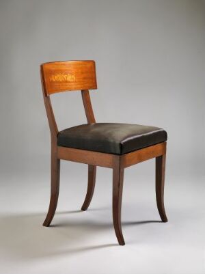  An elegant chair with a curved honey-toned wooden backrest and black upholstered seat stands against a light gray to white gradient background, highlighting the warm wood texture and the contrast of the black seat.