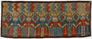  An antique textile artwork titled "Jomfruer" by an unidentified female artist, showcasing stylized human figures in a repetitive pattern, woven in a Flemish tapestry technique with vibrant reds, blues, and golds on a richly patterned abstract background.