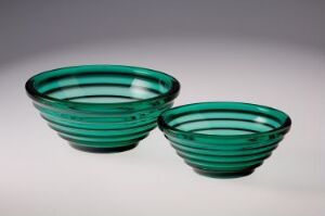  Two teal green glass bowls with ribbed design by Hadeland Glassverk, displayed against a light grey background, showcasing elegance and simplicity.