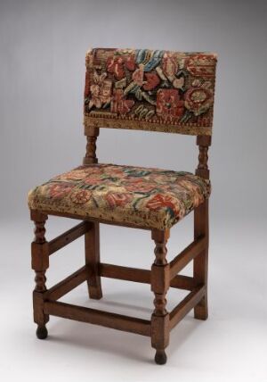  A traditional wooden chair titled "Stol" by an unidentified artist, made of stained beechwood with padded seat and back upholstered with colorful floral embroidery, secured with brass nail heads.