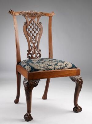  A mahogany Chippendale chair titled "Stol" featuring intricate open carvings in the backrest and claw-and-ball feet, with a velvet upholstered seat patterned in blues and greens.