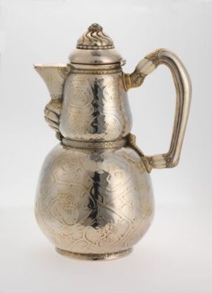  A silver teapot with etched patterns, a curved handle, and decorative finial on the lid, set against a neutral background. Artist and title are unknown.