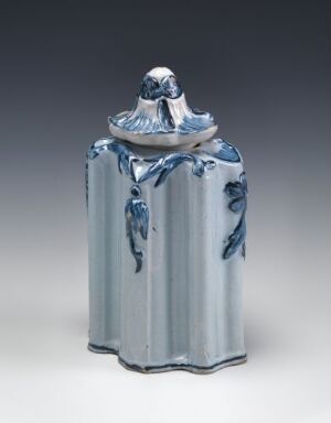  A rectangular, fluted faience tableware piece with a glossy white glaze and hand-painted cobalt blue details. The lid on top has a rounded knob handle, and the object displays the characteristic vertical ridges and a soft blue overall tone. Artist name unknown.