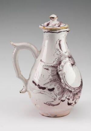  A vintage white-glazed fajanse pitcher with hand-painted manganrødt decorations by Herrebøe Fajansefabrikk, featuring an elegant handle and decorative lid.