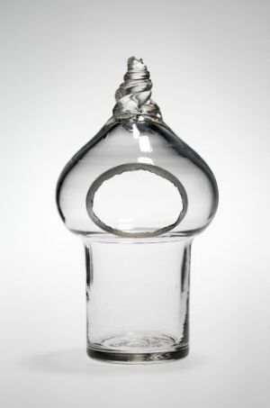  An artistic clear glass bottle with a cylindrical base and an ornate looped design at the top, set against a light gray gradient background.