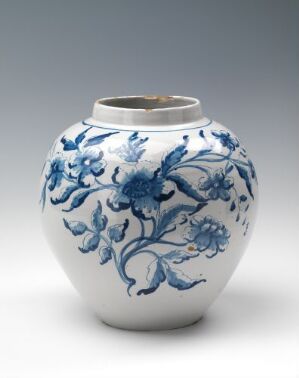  An image of 'Proprie eller Stinke-Krukke,' a white-glazed faience pot with intricate cobalt blue hand-painted floral motifs. The pot has a spherical body with a small opening on top, showcasing its design and craftsmanship. The artist of this piece is unknown.