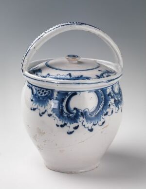  A white-glazed fajanse container with hand-painted cobalt blue decorative motifs made by Herrebøe Fajansefabrikk, featuring a handle and a matching lid.