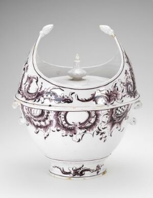  An intricately hand-painted fajanse (earthenware) tureen-like vessel with manganese-red decorative patterns on a glossy white glaze, featuring curved handles and a detailed finial on the lid, designed by Herrebøe Fajansefabrikk.