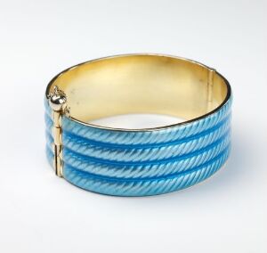  A wide, hinged cuff bracelet with diagonal blue and white stripes and a lustrous gold interior.