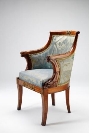  Antique armchair with a polished mahogany wooden frame and tapestry-style upholstery in shades of light blue, green, and beige featuring pastoral patterns on the backrest and seat.