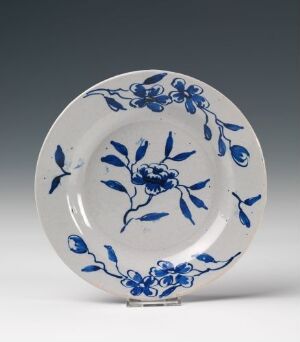  A traditional white ceramic plate with intricate cobalt blue floral patterns and leaves, reflective of East Asian ceramic design.