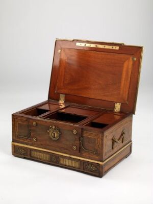  An antique mahogany writing box with brass accents is open, displaying various compartments and a velvet-lined lid interior.