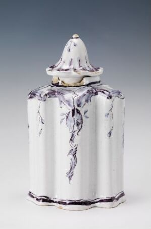  A white-glazed fajanse container with hand-painted manganese red vine patterns, featuring a scalloped lid with a conical handle, set against a neutral grey background. Artist is unknown.