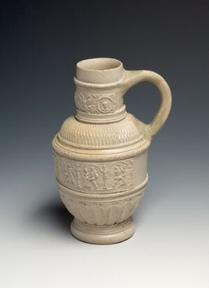  A cream-beige stoneware jug titled "Bondedans" by Hans Sebald Beham, featuring wheel-thrown and modeled craftsmanship with salt glaze. The jug has a bulbous body with incised and carved relief decoration, a cinched neck, and a substantial handle, set against a dark gradient background.